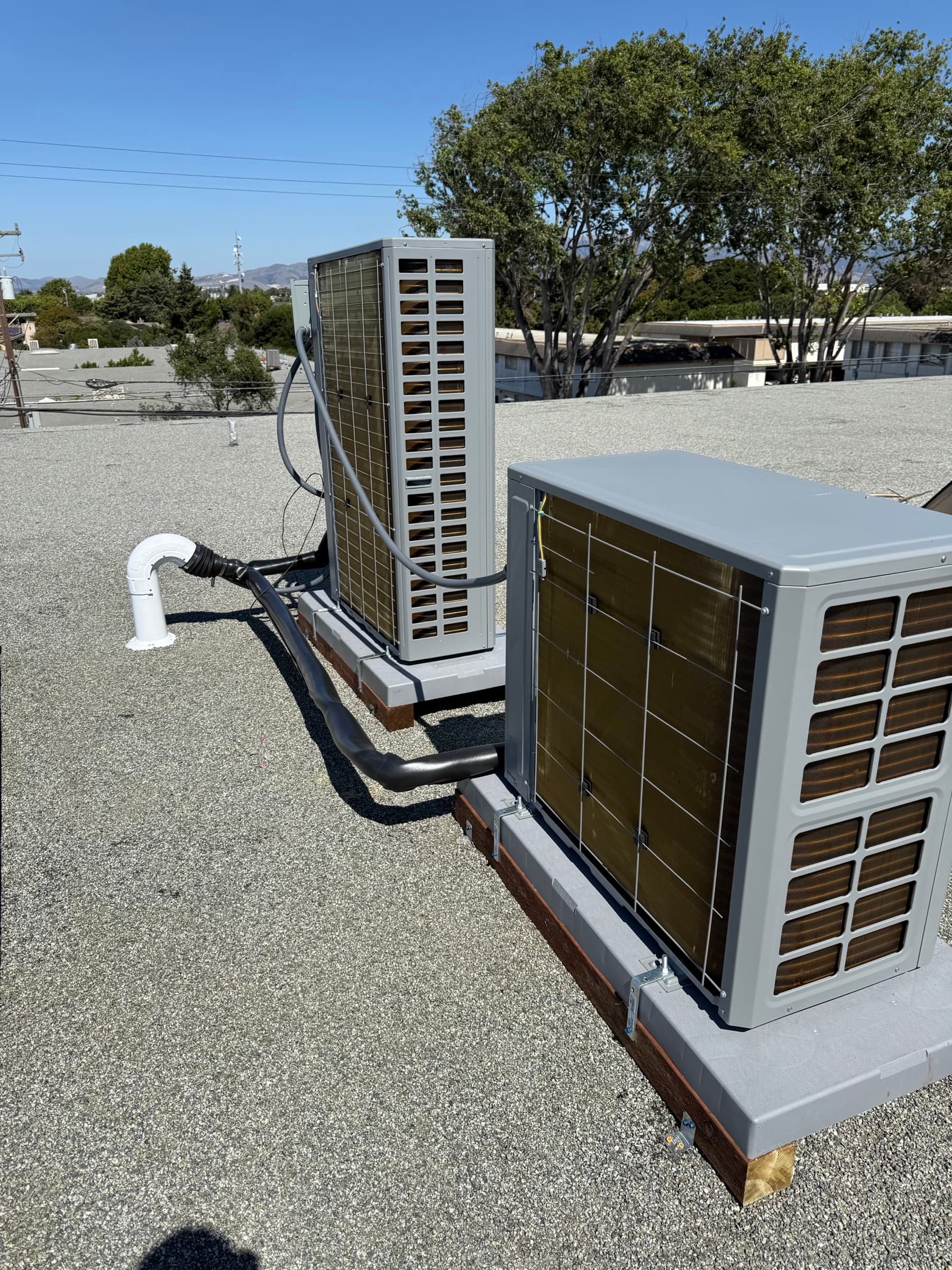 Two TOSOT heat pump units installed on a flat roof
