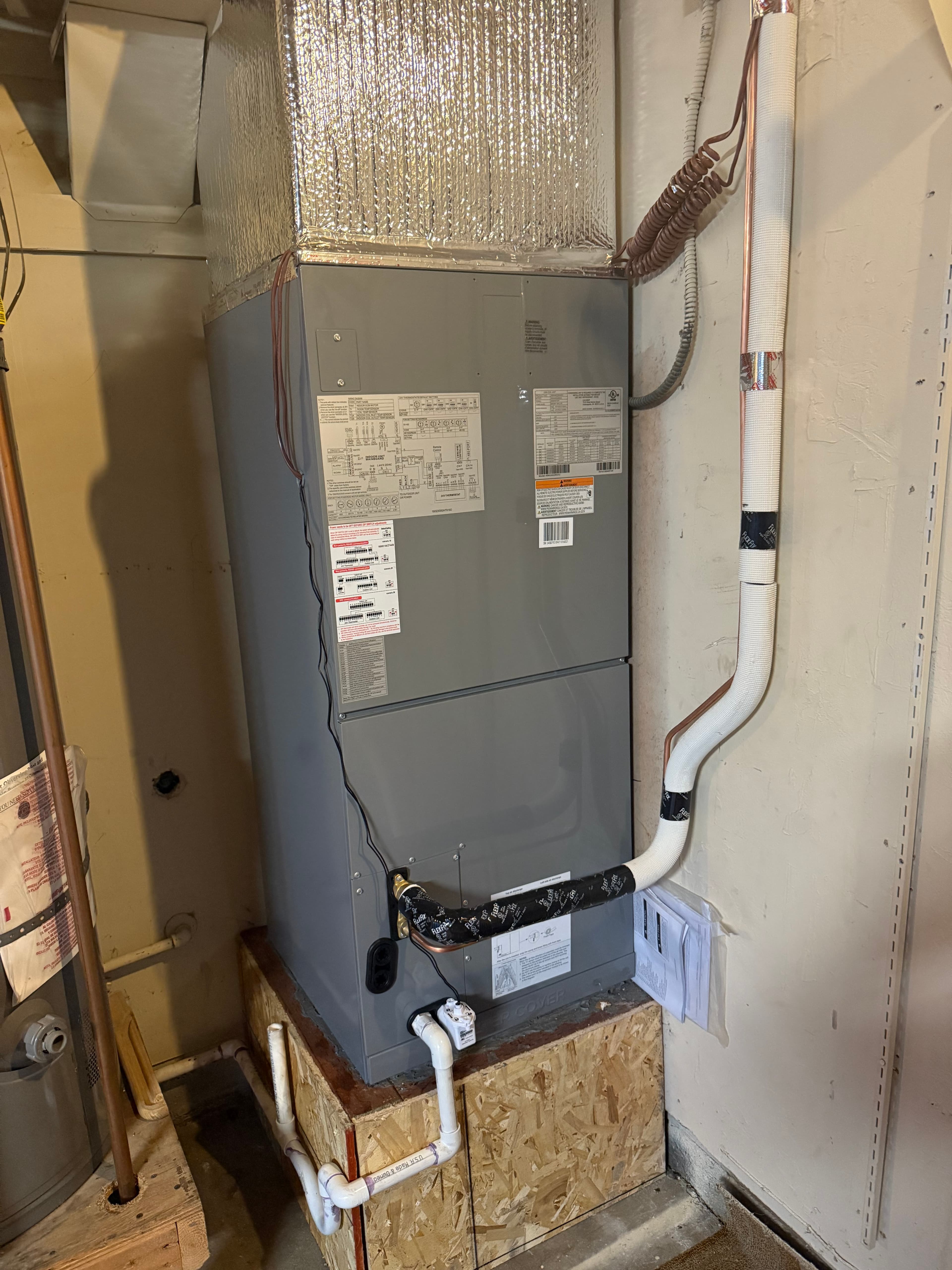 Furnace on raised platform in utility closet